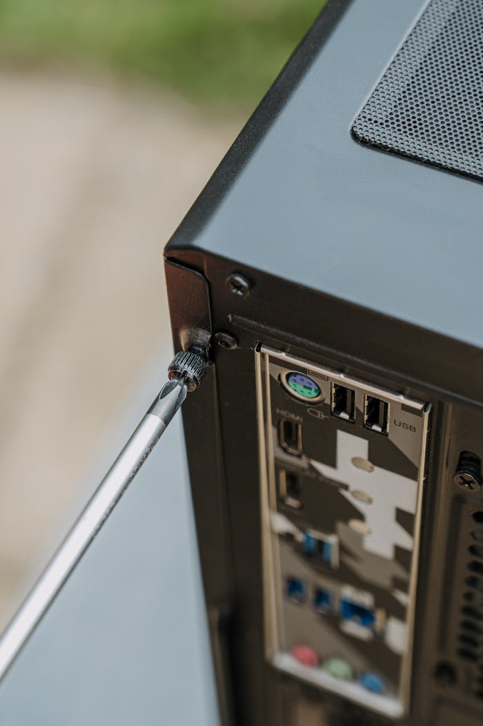 gallery-03 Close-up of unscrewing a PC's back panel for DIY maintenance.