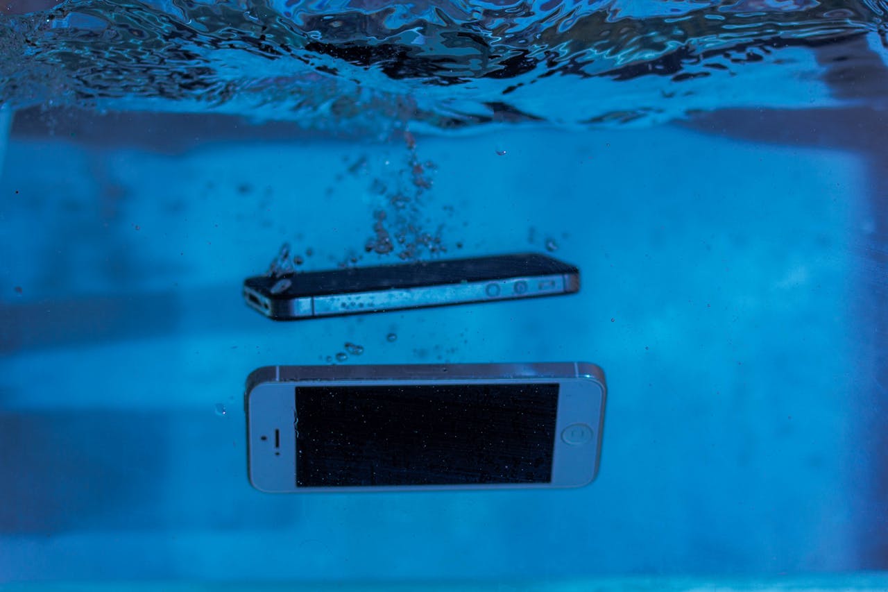 portfolio-02 Two smartphones immersed underwater with bubbles, showcasing water-resistant test perspectives.